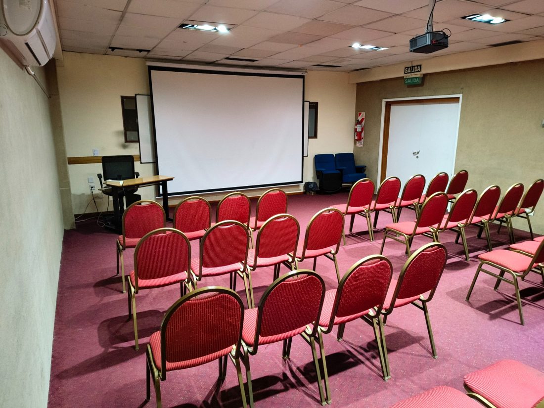 Sala armada como auditorio con pantalla retráctil
